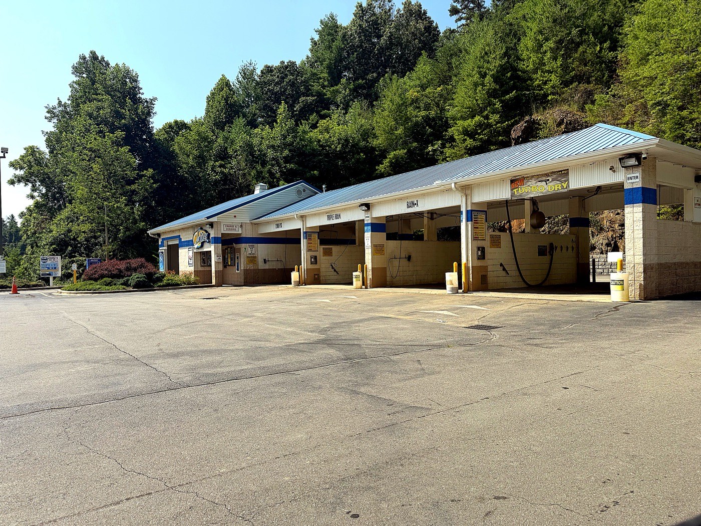 Car Crazy car wash building with a blue metal roof and open wash bays in Mars Hill, NC